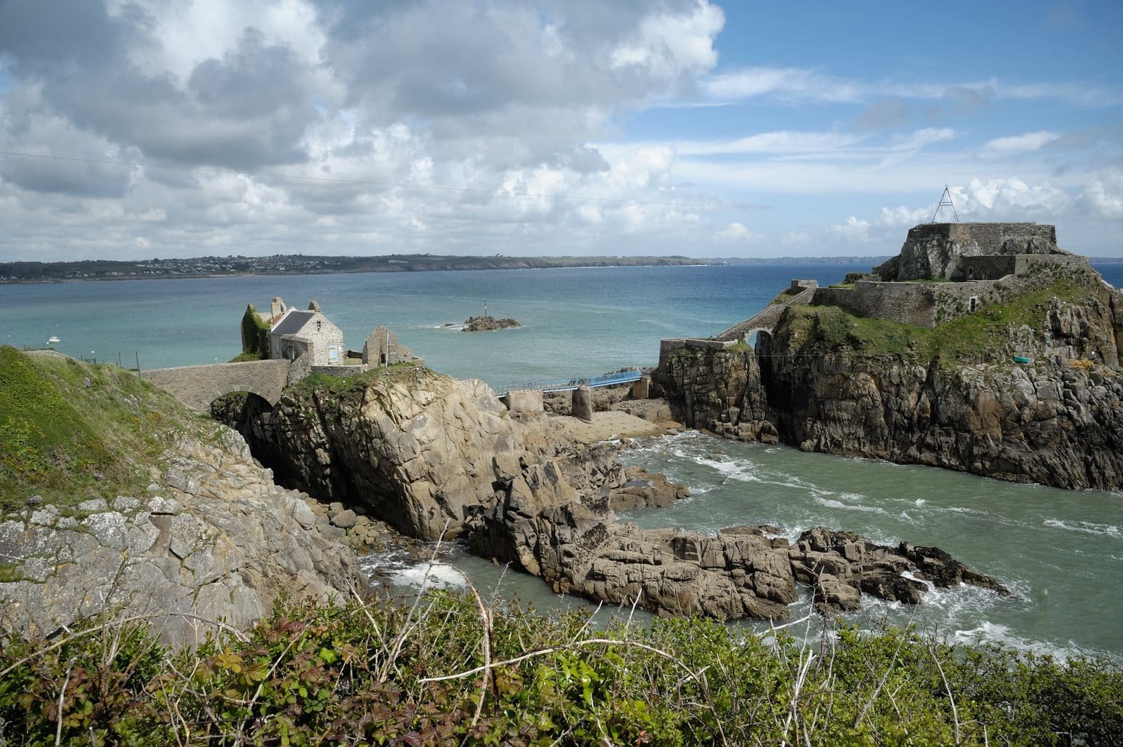 Photo by Thierry coulon A breathtaking view of the coastline in Bretagne, France featuring an ancient fort and rugged cliffs.